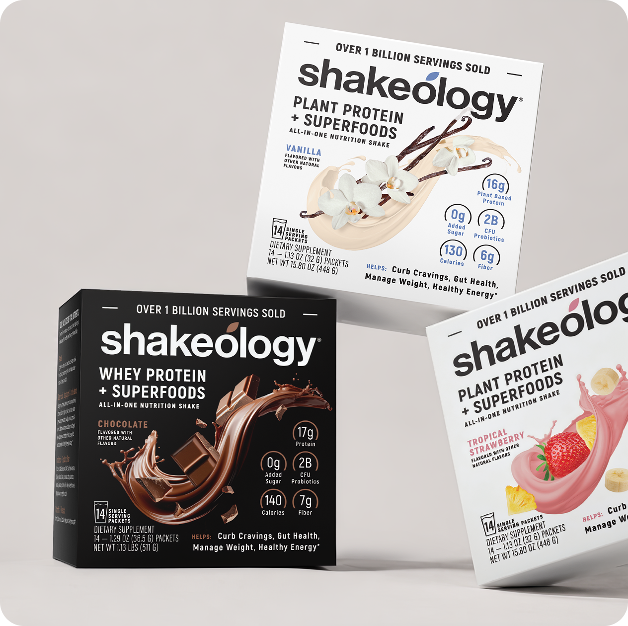 Three Shakeology protein powder boxes arranged together on a black background: a vanilla plant protein + superfoods box at the top right, a chocolate whey protein + superfoods box at the bottom left, and a tropical strawberry flavor box at the bottom right. The Shakeology brand name is prominently visible on all boxes.